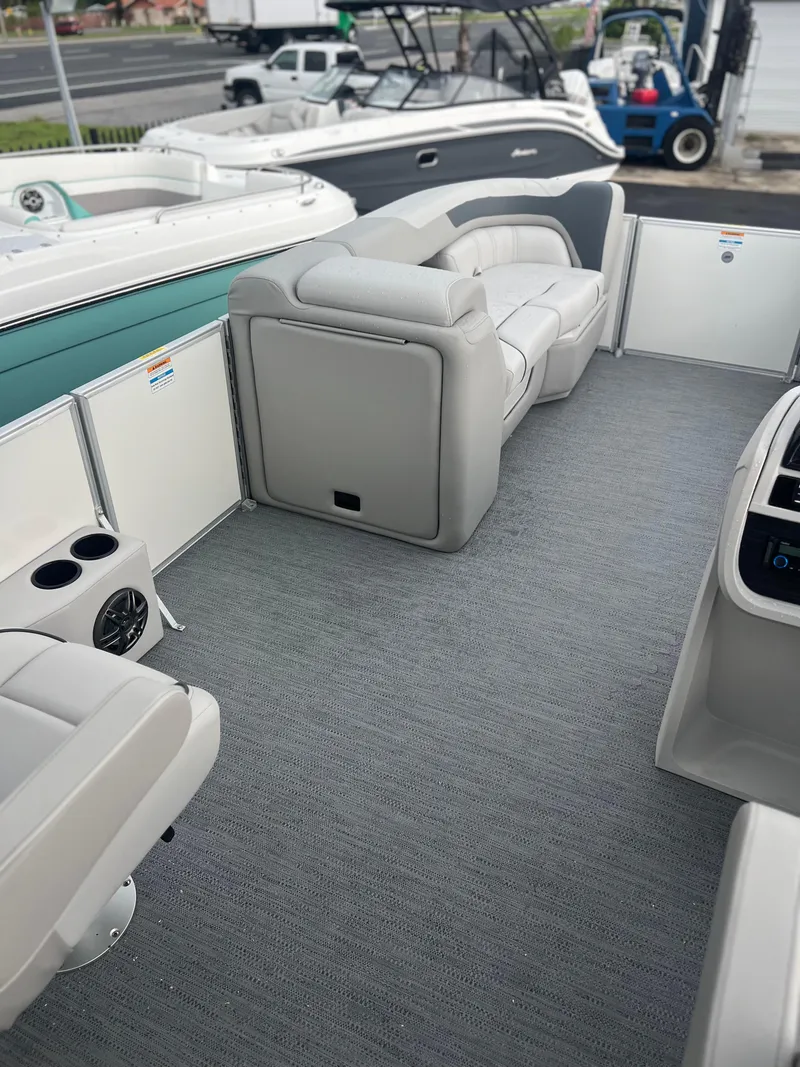 Slide: The Image of 2026 Sweetwater 2286SFLC pontoon boat interior with gray seating and carpet. - 13