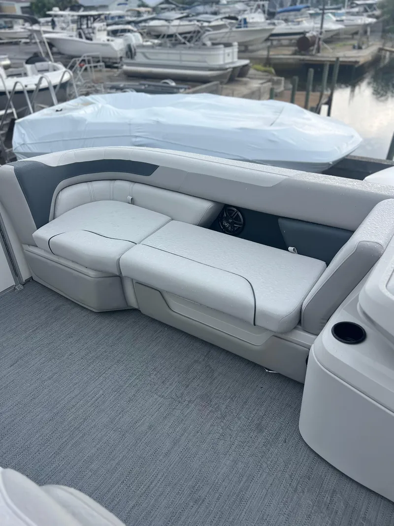 Slide: The Image of 2026 Sweetwater 2286SFLC boat interior with gray seating at a marina. - 14