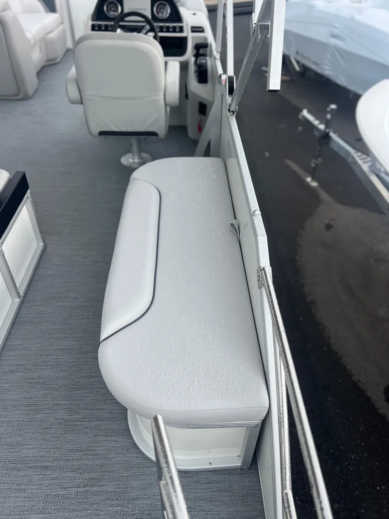 Slide: The Image of Interior of 2026 Sweetwater 2286SFLC boat with white seating and steering console. - 16