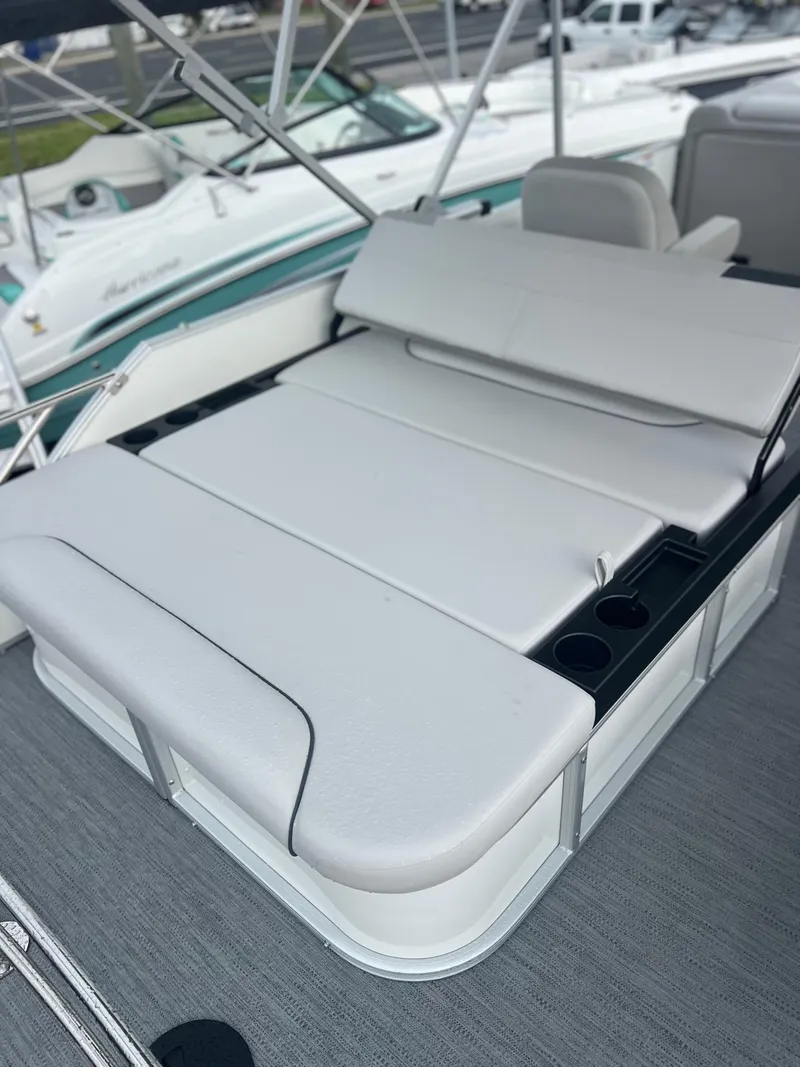 Slide: The Image of 2026 Sweetwater 2286SFLC boat with white cushioned seating and cup holders. - 5