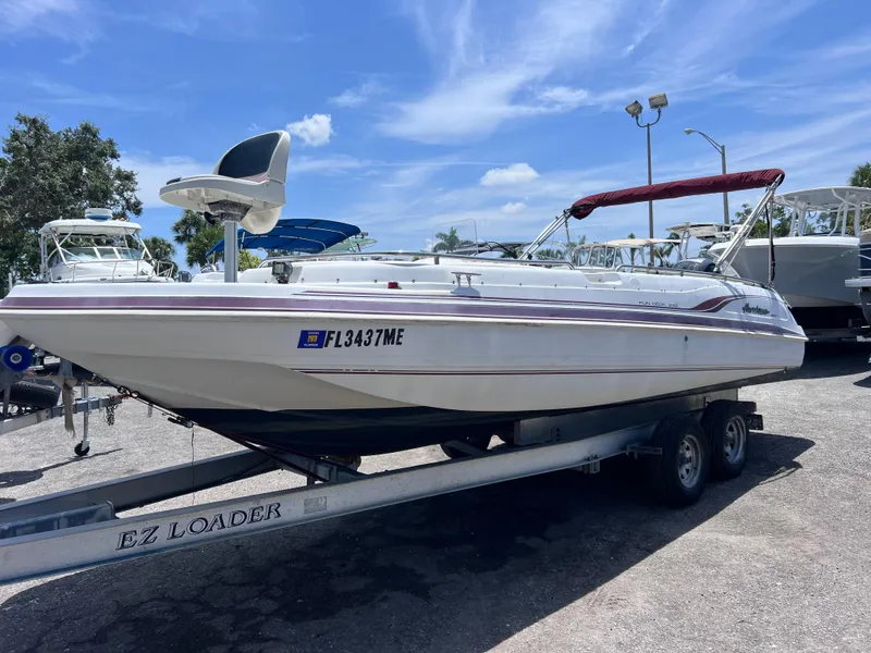 The Image of 2000 Hurricane FunDeck GS 232 OB boat on trailer under clear blue sky. - 0