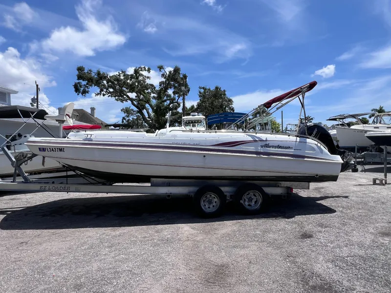 Slide: The Image of 2000 Hurricane FunDeck GS 232 OB boat on trailer under clear blue sky. - 2