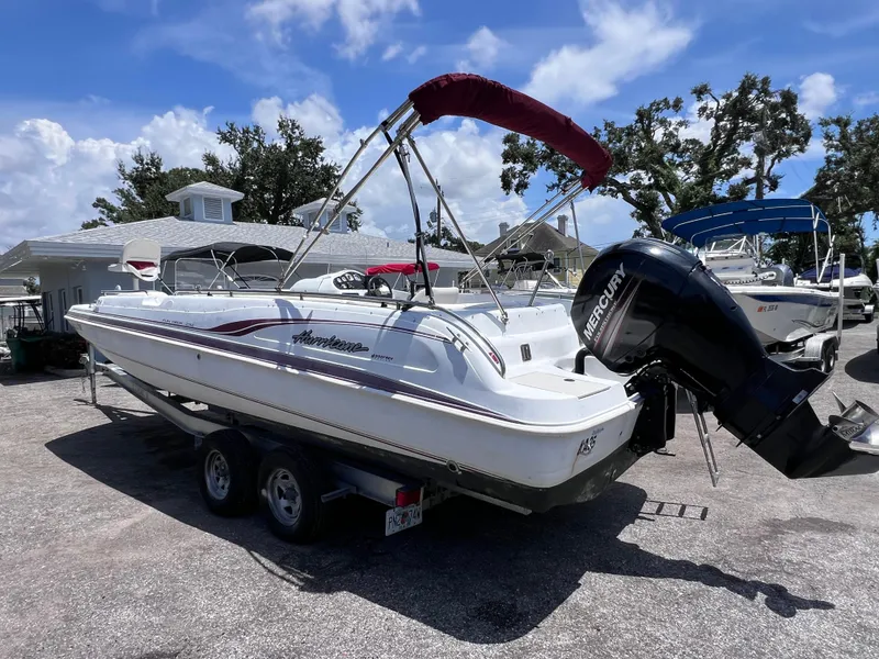 Slide: The Image of 2000 Hurricane FunDeck GS 232 OB boat with Mercury outboard motor on trailer, parked outdoors. - 3
