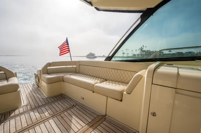 Slide: The Image of 2014 Chris-Craft Corsair 36 Hard Top yacht with American flag, elegant seating, and teak deck. - 38
