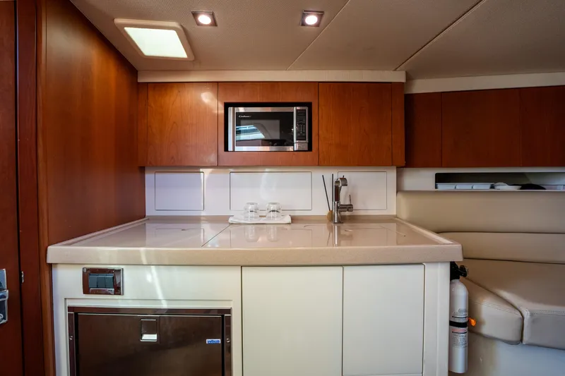Slide: The Image of 2014 Chris-Craft Corsair 36 Hard Top interior kitchen with microwave and wooden cabinetry. - 41