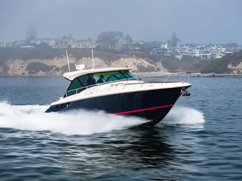 Slide: The Image of 2014 Chris-Craft Corsair 36 Hard Top cruising on water near coastal cliffs. - 19