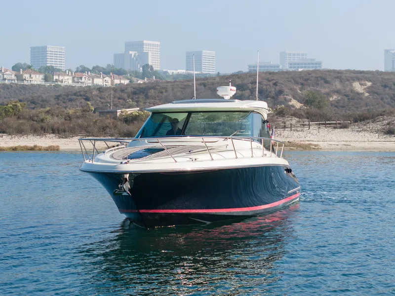 Slide: The Image of 2014 Chris-Craft Corsair 36 Hard Top yacht on calm water near a coastal cityscape. - 11