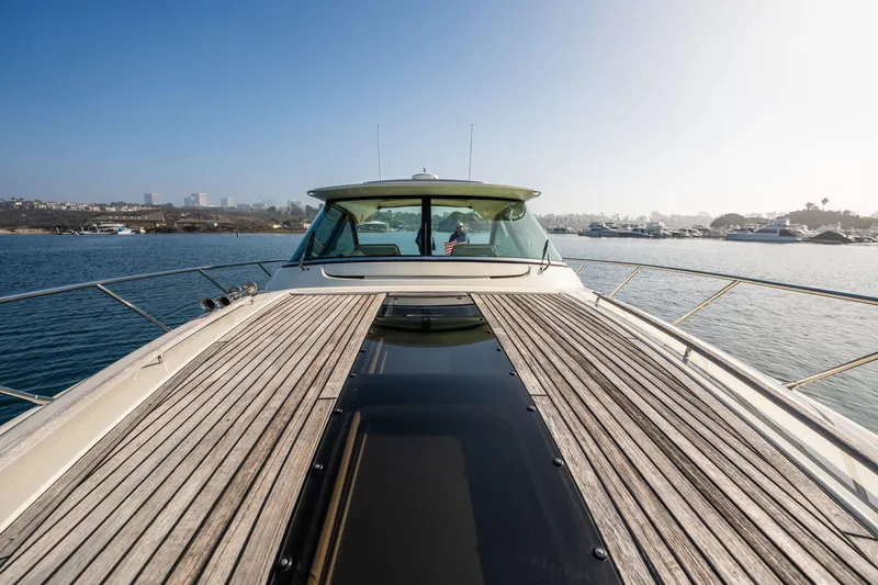 Slide: The Image of 2014 Chris-Craft Corsair 36 Hard Top yacht on calm water, showcasing sleek design and wooden deck. - 31