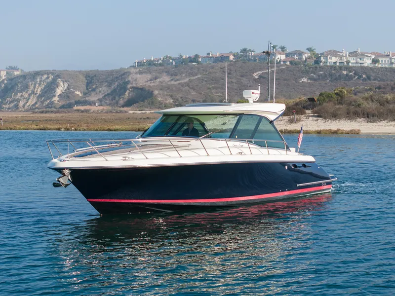 Slide: The Image of 2014 Chris-Craft Corsair 36 Hard Top boat on calm water near coastal cliffs. - 10