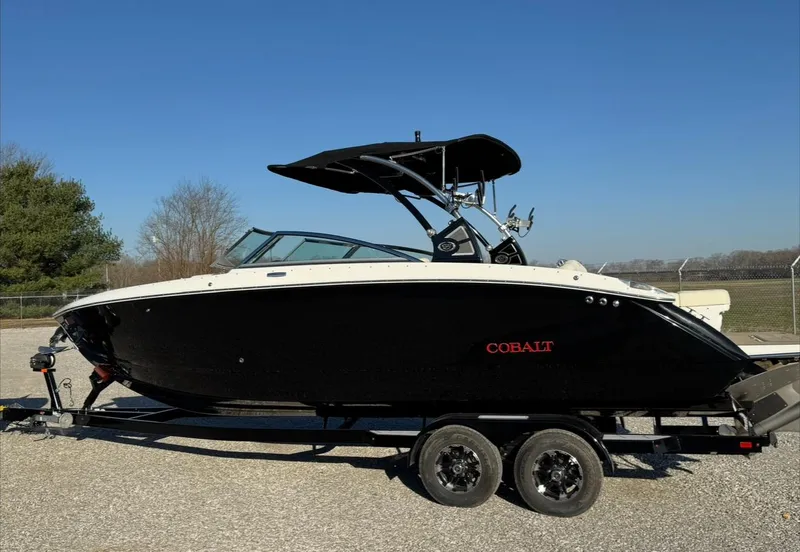 Slide: The Image of 2020 Cobalt R7 Surf boat on trailer, black and white design, parked outdoors. - 0