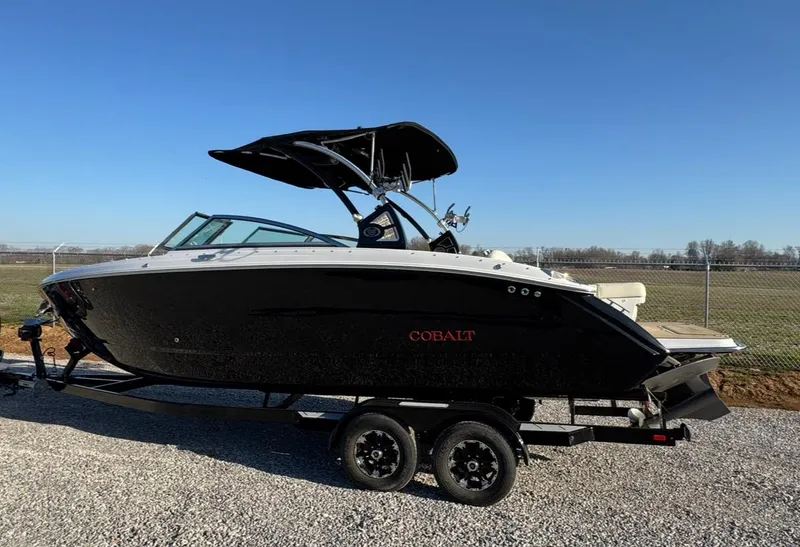 Slide: The Image of 2020 Cobalt R7 Surf boat on trailer, black exterior, parked on gravel. - 13