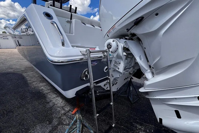 Slide: The Image of 2026 Tidewater 272 LXF boat with outboard motor and ladder, parked on pavement. - 10