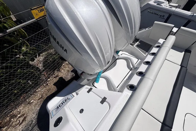 Slide: The Image of 2026 Tidewater 272 LXF boat with dual Yamaha outboard engines, docked near a fence. - 15