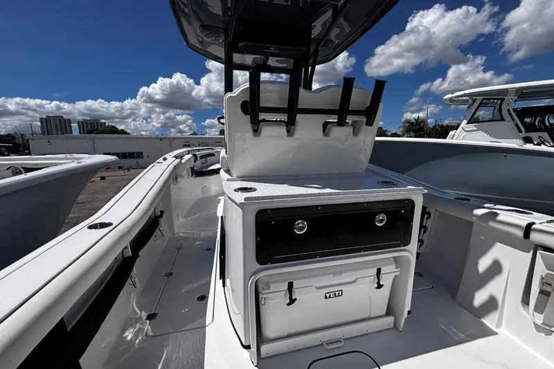 Slide: The Image of 2026 Tidewater 272 LXF boat interior with storage and cooler under a clear blue sky. - 22