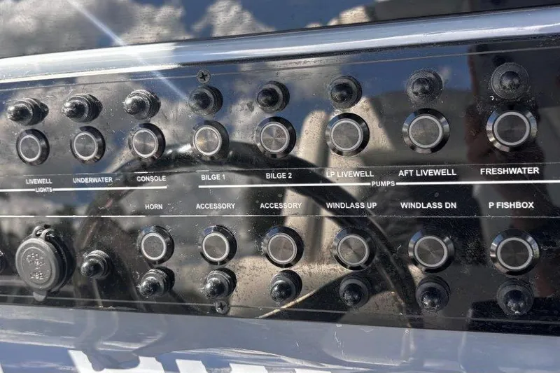 Slide: The Image of Control panel of a 2026 Tidewater 272 LXF boat with various switches. - 29