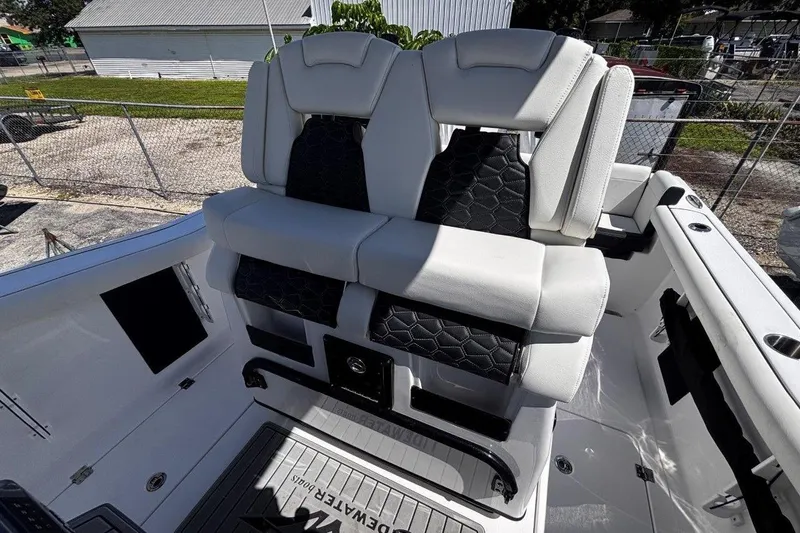 Slide: The Image of 2026 Tidewater 272 LXF boat seating with white and black upholstery, docked outdoors. - 30