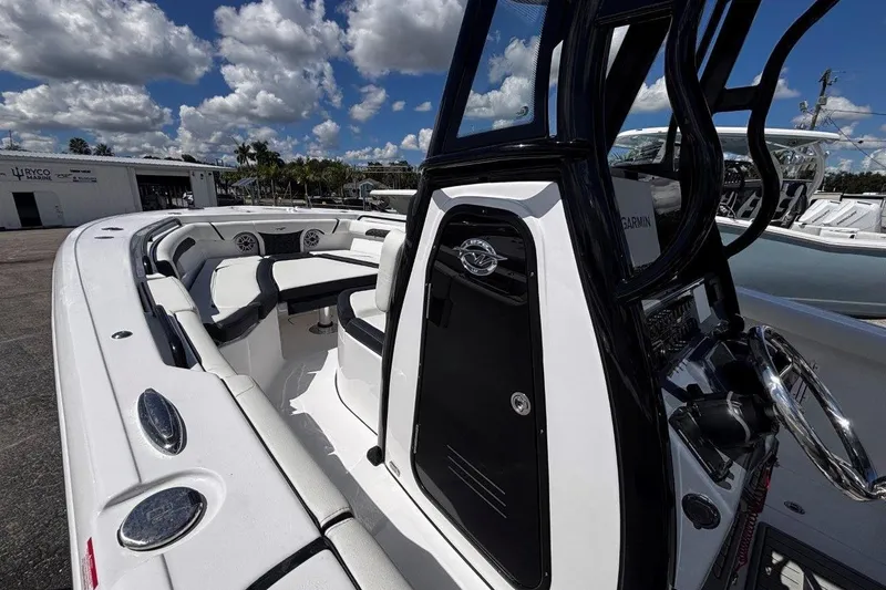 Slide: The Image of 2026 Tidewater 272 LXF boat interior with seating and steering console under a blue sky. - 33