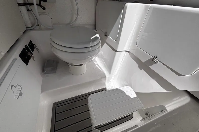 Slide: The Image of 2026 Tidewater 272 LXF boat interior with compact marine toilet setup. - 35