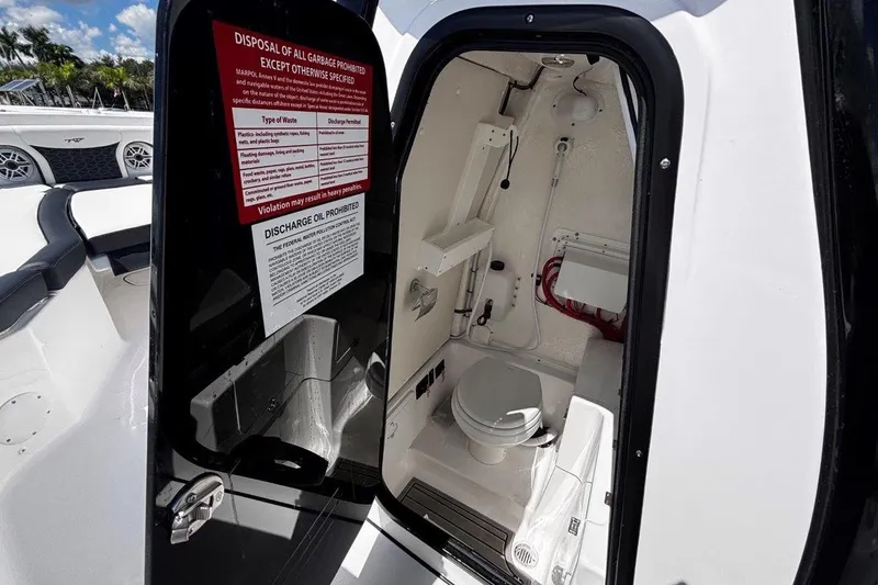 Slide: The Image of 2026 Tidewater 272 LXF boat interior with open restroom door and visible toilet. - 38