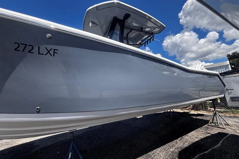 Slide: The Image of 2026 Tidewater 272 LXF boat with sleek gray hull under a blue sky. - 4