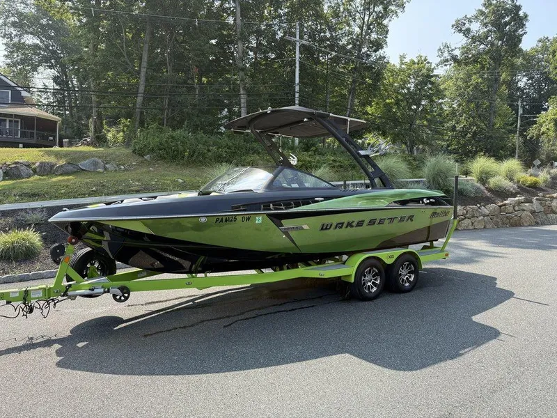 Slide: The Image of 2015 Malibu 22 VLX Wakesetter boat on trailer, parked on a sunny road. - 10