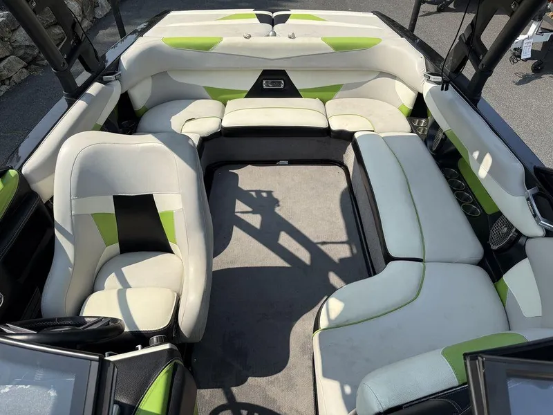 Slide: The Image of 2015 Malibu 22 VLX boat interior with white and green seating, spacious layout. - 11