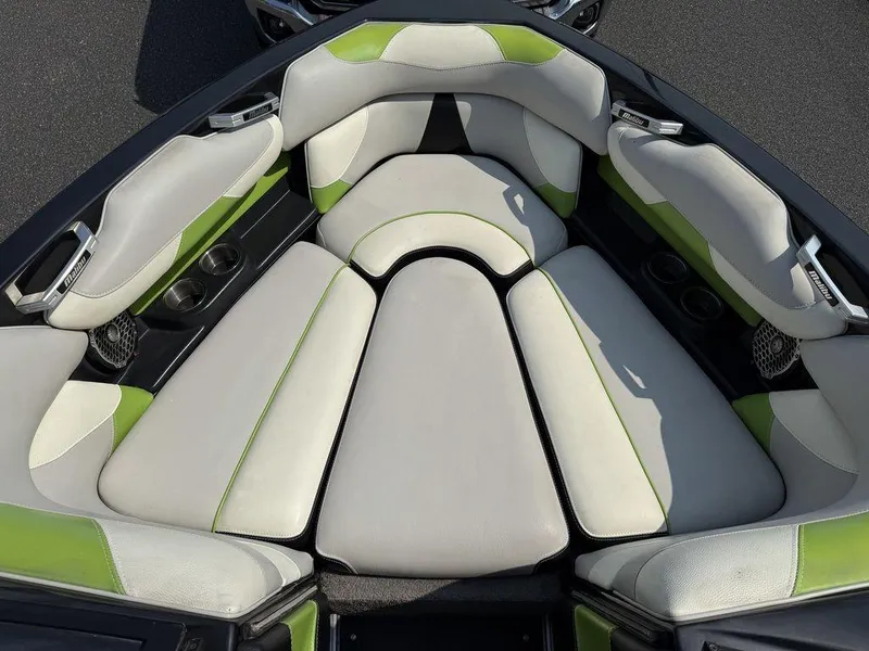 Slide: The Image of 2015 Malibu 22 VLX boat interior with green and white cushioned seating. - 13