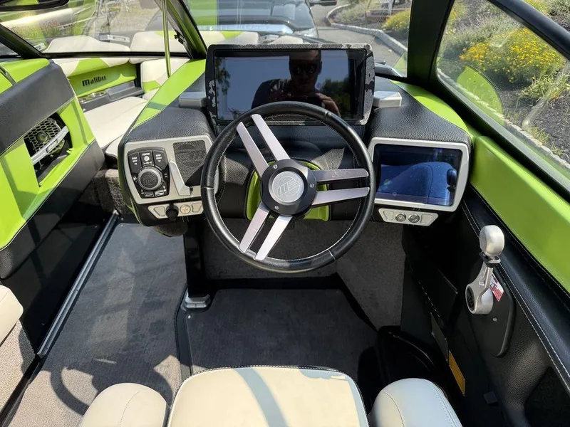 Slide: The Image of Interior of a 2015 Malibu 22 VLX boat with modern dashboard and steering wheel. - 14