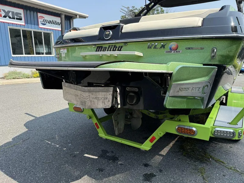Slide: The Image of 2015 Malibu 22 VLX boat with Surf Gate system, parked on a trailer. - 3