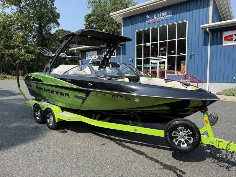Slide: The Image of 2015 Malibu 22 VLX boat on trailer outside marine shop. - 5