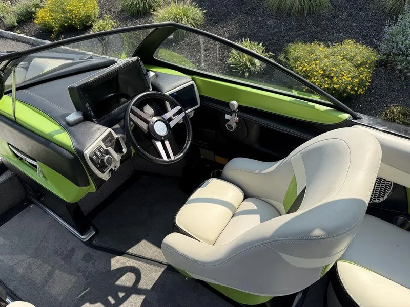 Slide: The Image of 2015 Malibu 22 VLX boat interior with green accents and modern steering console. - 6