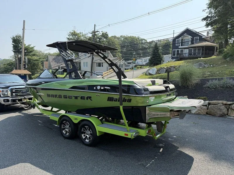 Slide: The Image of 2015 Malibu 22 VLX Wakesetter boat on trailer, parked in residential area. - 9