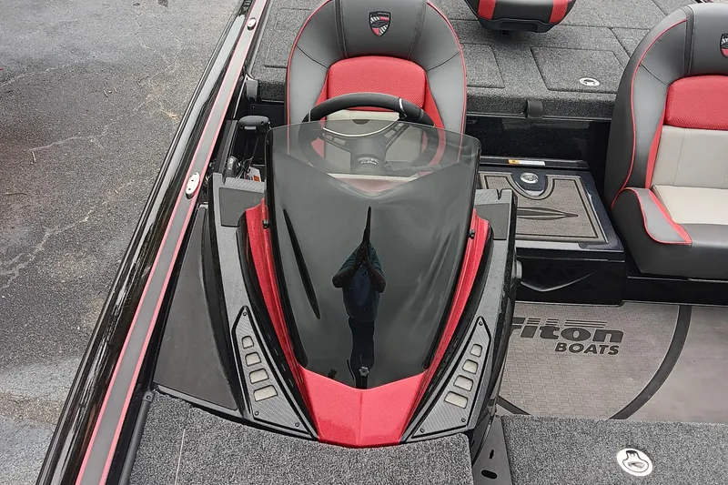 Slide: The Image of 2025 Triton 20XP boat cockpit with red and gray seats, steering wheel, and windshield. - 10