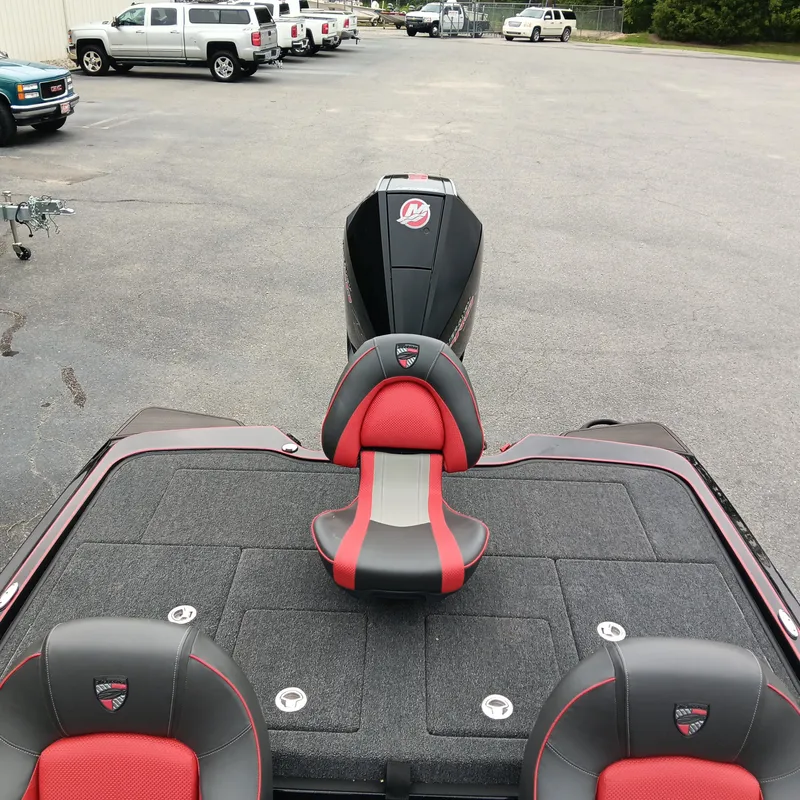 Slide: The Image of 2025 Triton 20XP boat with red and black seating, parked in a lot. - 14