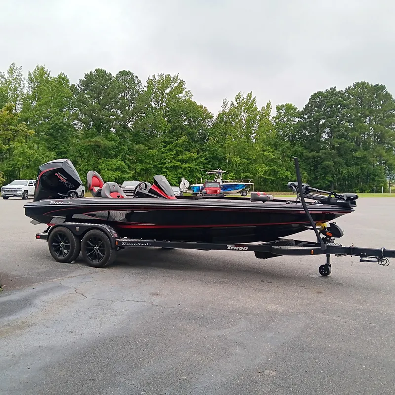 Slide: The Image of 2025 Triton 20XP boat on trailer, parked outdoors with trees in background. - 3