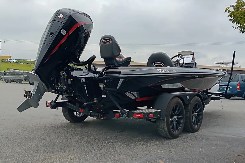 Slide: The Image of 2025 Triton 20XP boat on trailer, featuring sleek black design and powerful outboard motor. - 4