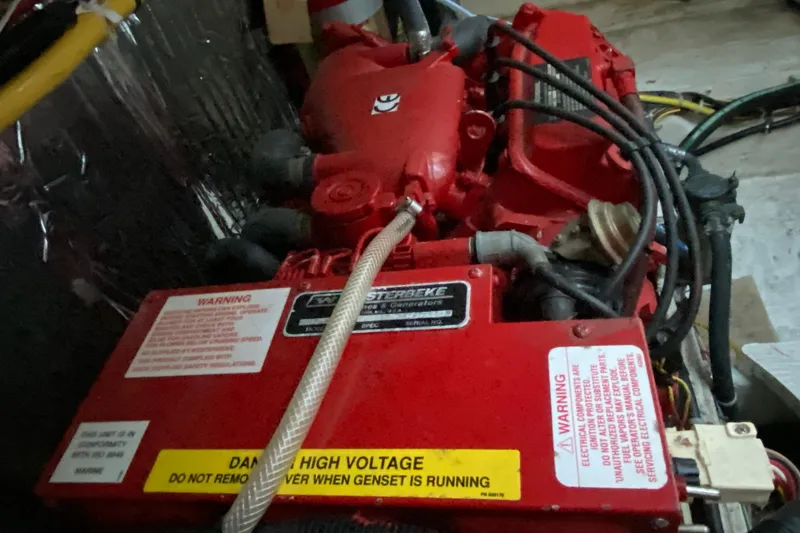Slide: The Image of Engine compartment of a 2005 Bayliner 325 with red components and warning labels. - 12