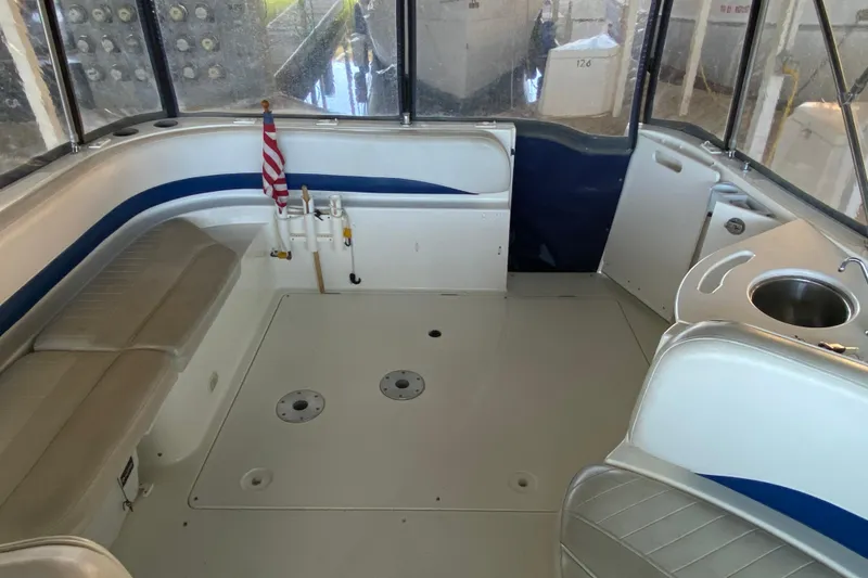 Slide: The Image of 2005 Bayliner 325 boat interior with seating, sink, and American flag. - 9