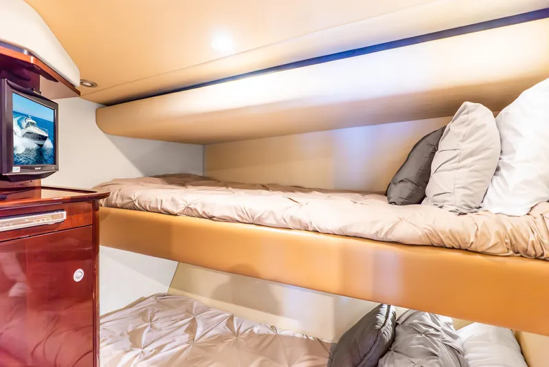 Slide: The Image of Interior of 2008 Sea Ray 60 Sundancer with cozy bunk beds and a small TV. - 16