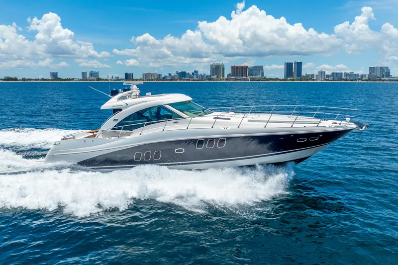 Slide: The Image of 2008 Sea Ray 60 Sundancer yacht cruising on blue ocean with city skyline background. - 3