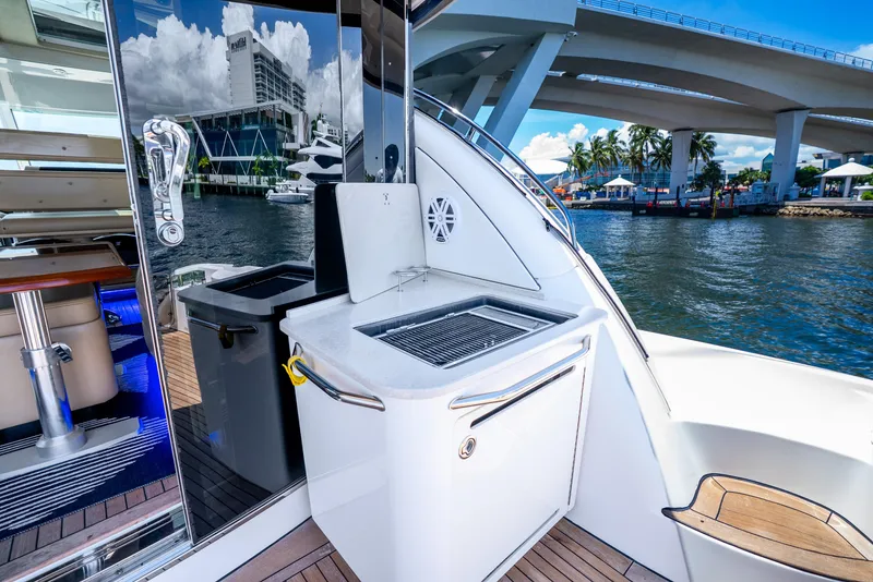 Slide: The Image of 2008 Sea Ray 60 Sundancer yacht with outdoor grill, docked near a bridge and waterfront buildings. - 31