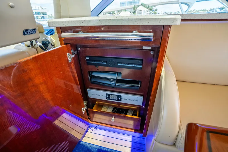 Slide: The Image of 2008 Sea Ray 60 Sundancer interior with open cabinet revealing electronic equipment. - 33