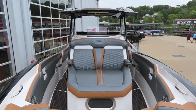 Slide: The Image of 2023 Sunsation 32 CCX boat with sleek seating and modern design at a marina. - 22