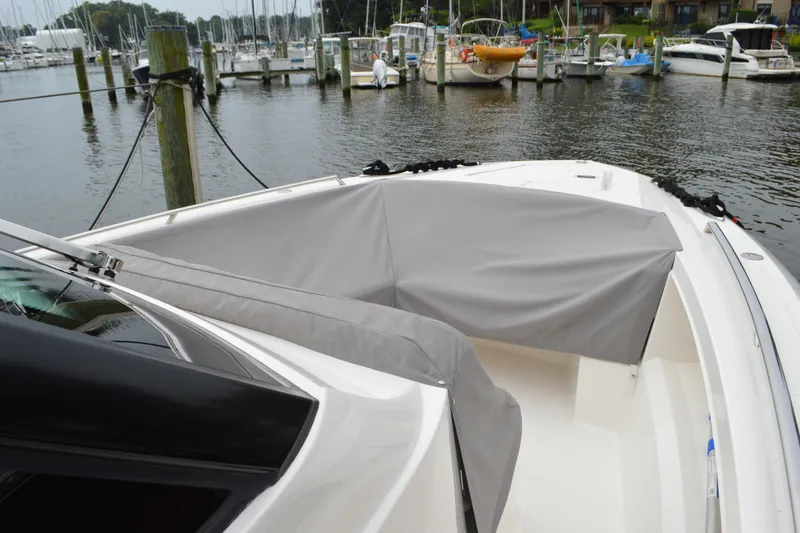 Slide: The Image of 2023 Tiara Yachts 34 LS boat with gray cover docked at marina. - 17