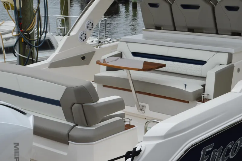 Slide: The Image of 2023 Tiara Yachts 34 LS interior with elegant seating and table, docked by the water. - 26