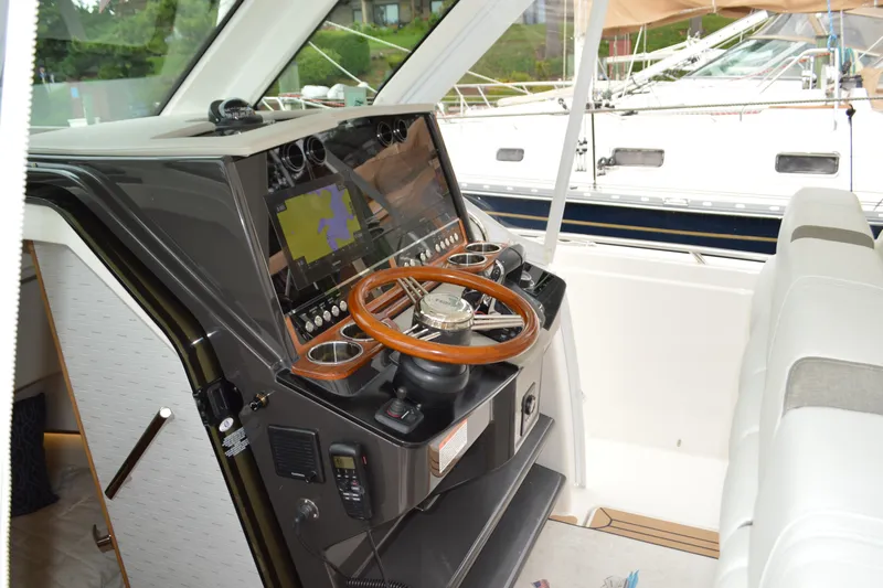 Slide: The Image of 2023 Tiara Yachts 34 LS helm with modern navigation equipment and wooden steering wheel. - 41