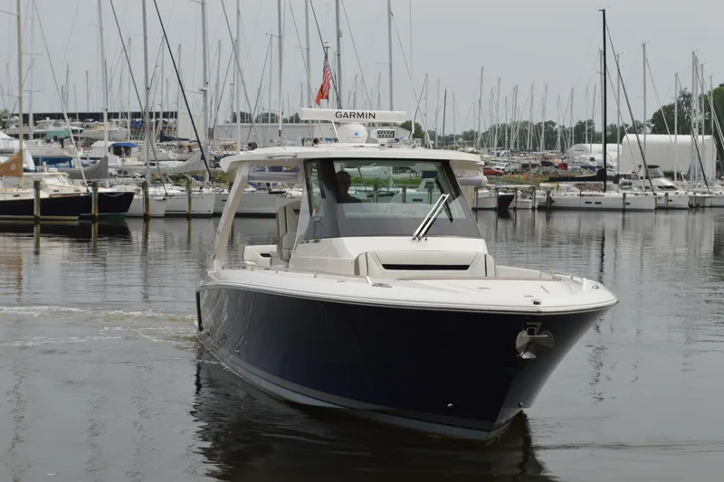 Slide: The Image of 2023 Tiara Yachts 34 LS in marina, surrounded by sailboats. - 5