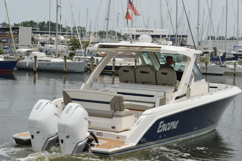 Slide: The Image of 2023 Tiara Yachts 34 LS boat with dual engines in a marina setting. - 6