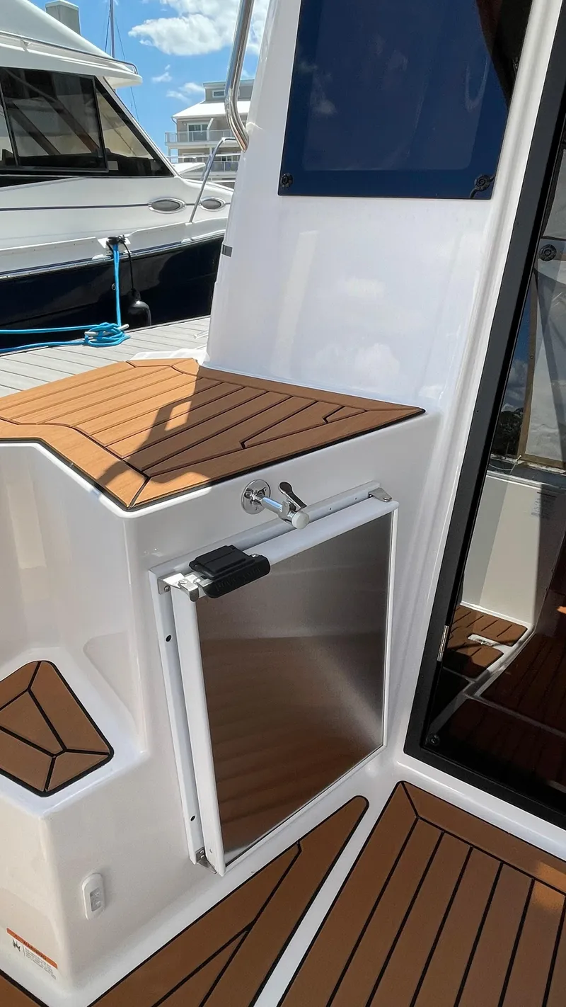 Slide: The Image of 2026 Ranger Tugs R-27 boat deck with wood finish and storage compartment. - 10