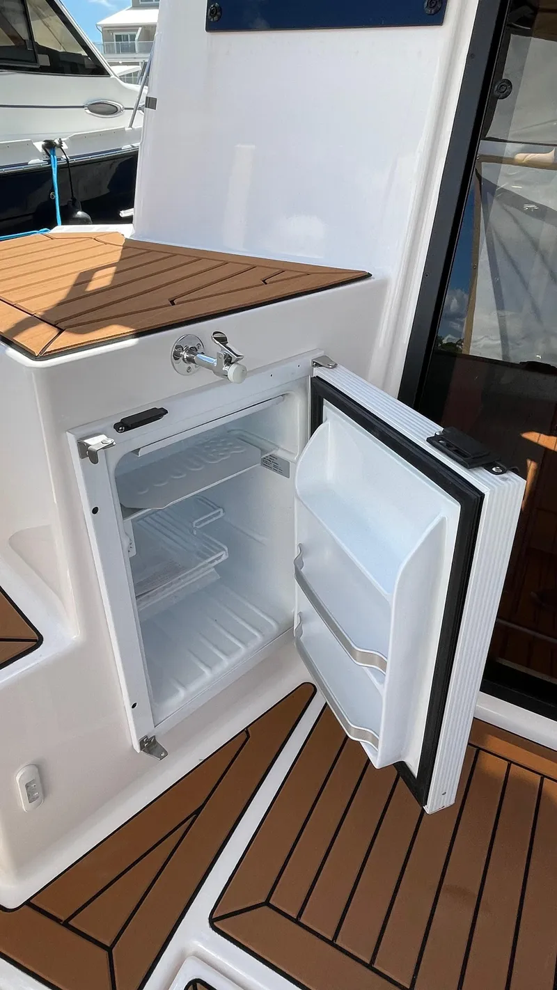 Slide: The Image of Open fridge on 2026 Ranger Tugs R-27 boat, showcasing teak deck and modern design. - 11